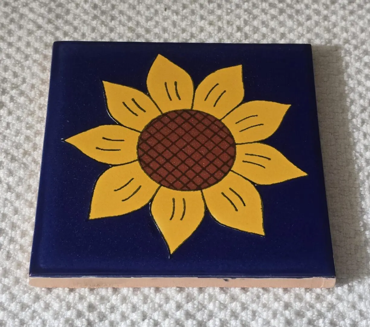 Blue ceramic tile with painted sunflower