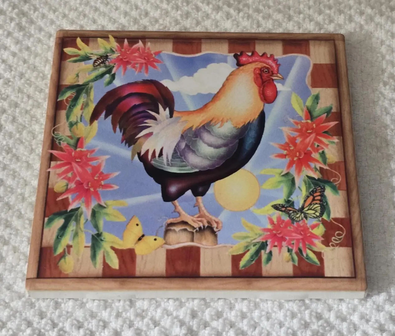 Colorful rooster art with flowers and butterflies.