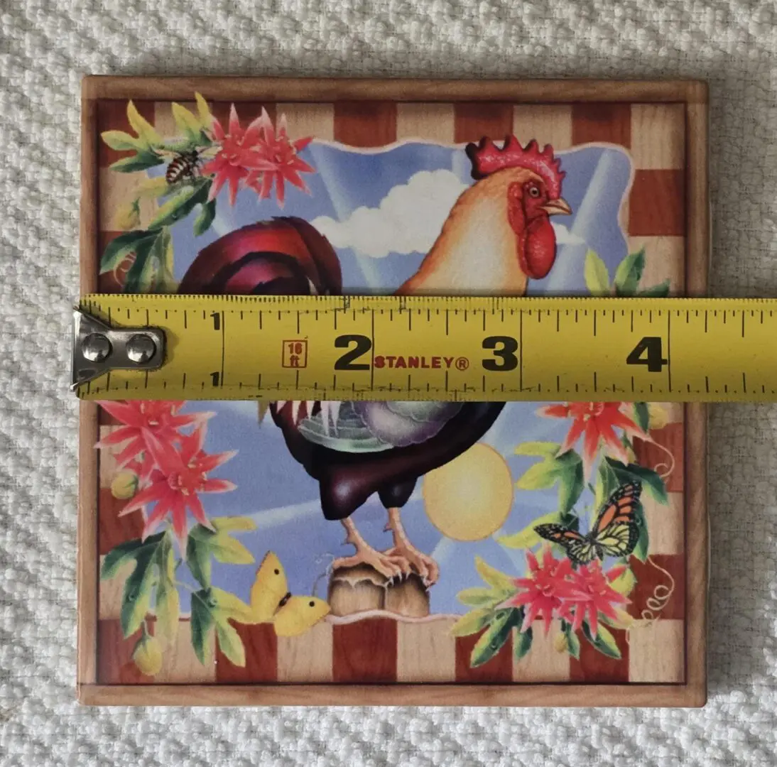 Rooster tile with tape measure across it.