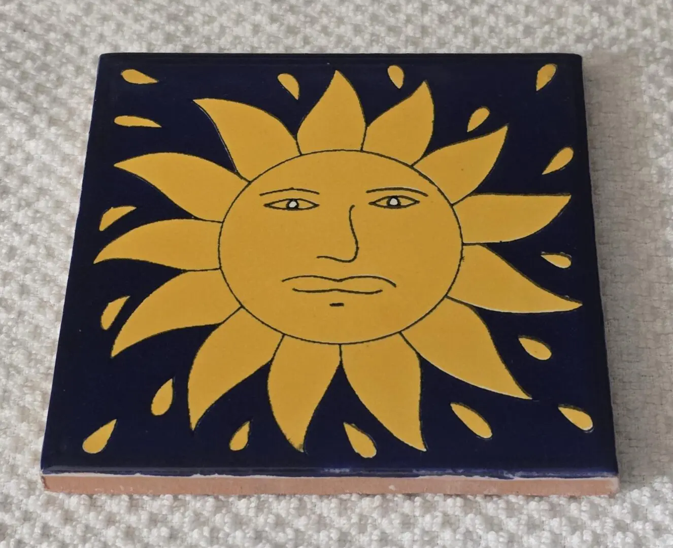 Yellow sun design on decorative tile.