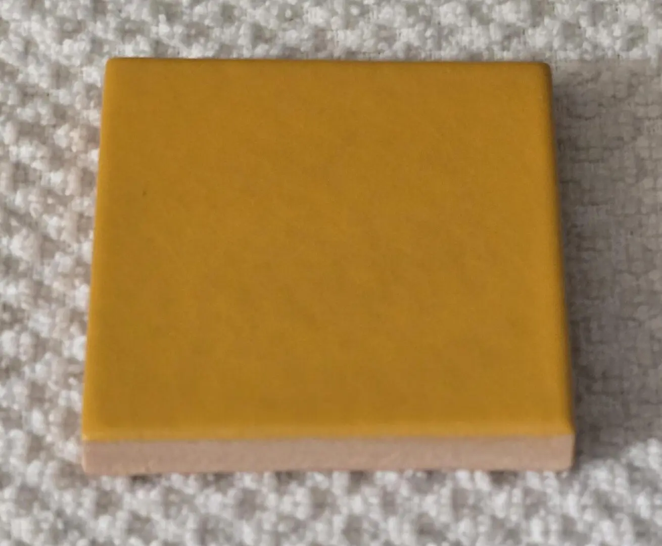 small square yellow block on textured white fabric