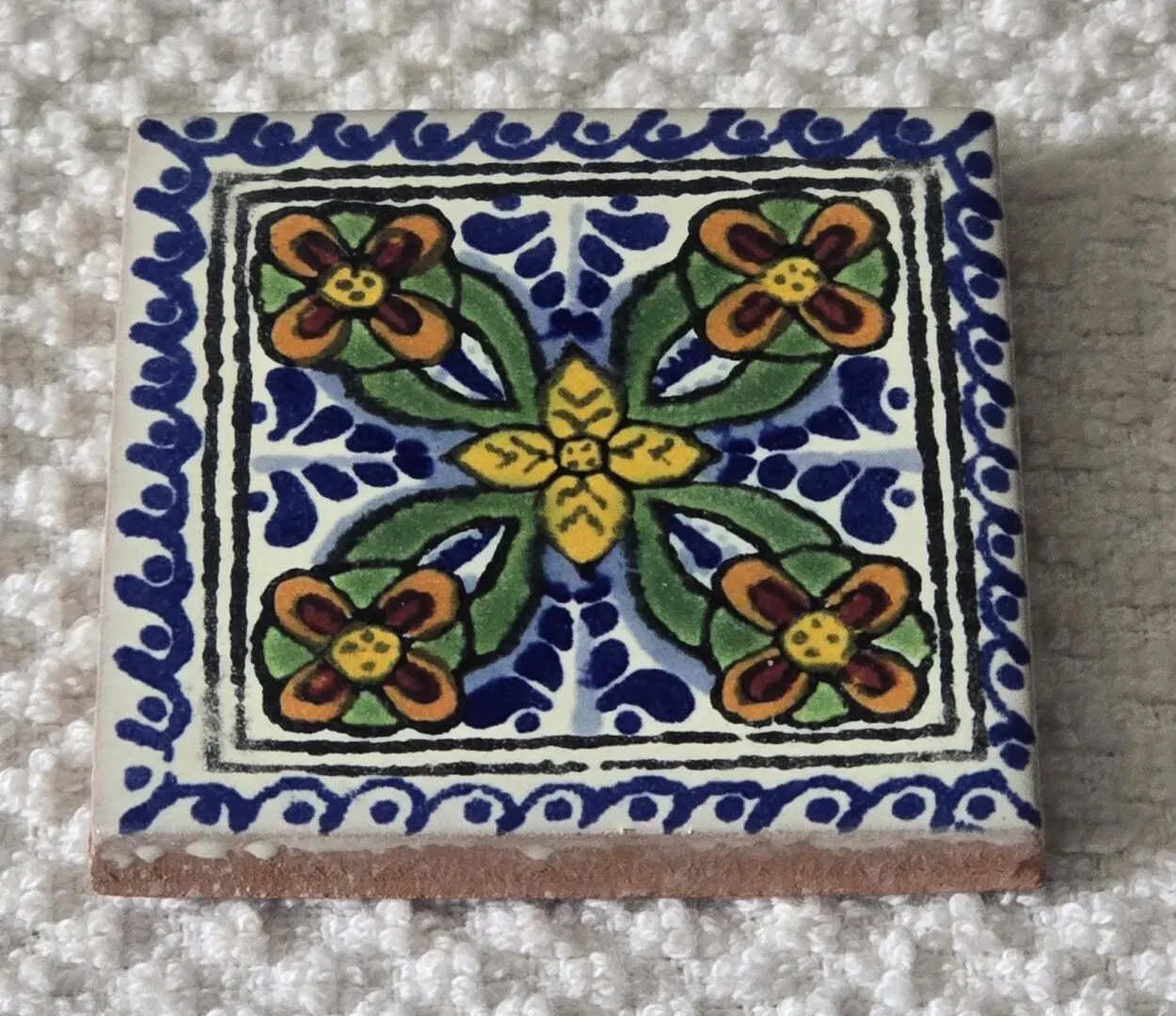 Hand-painted ceramic tile with floral pattern