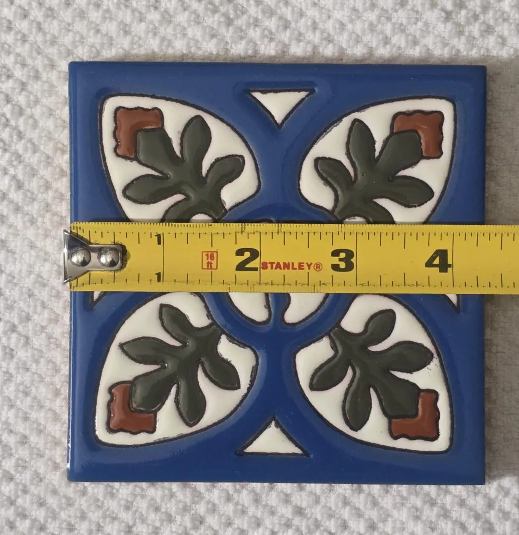 Square blue ceramic tile with green leaf motifs