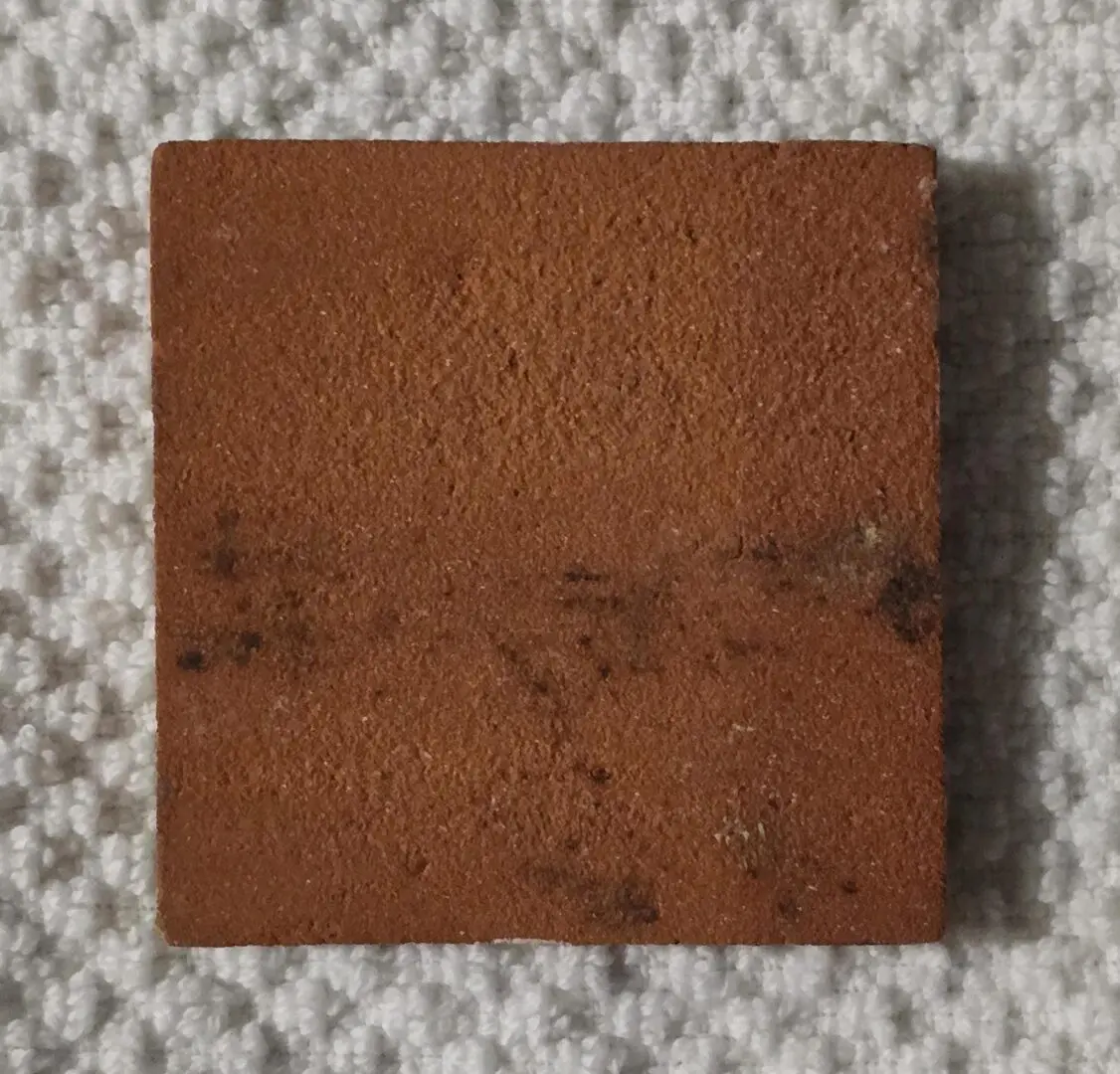 Close-up of a small, square, textured brown leather piece.