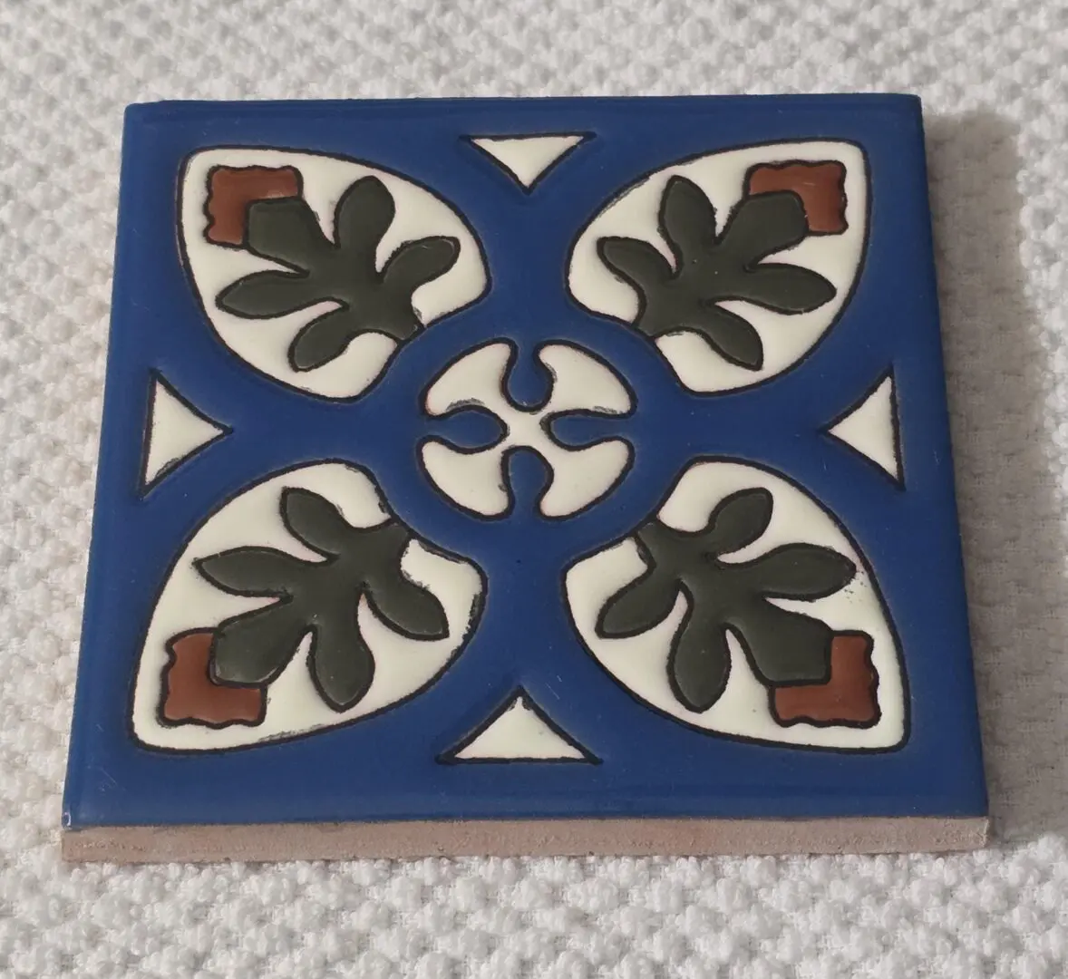 Blue square tile with stylized leaf pattern