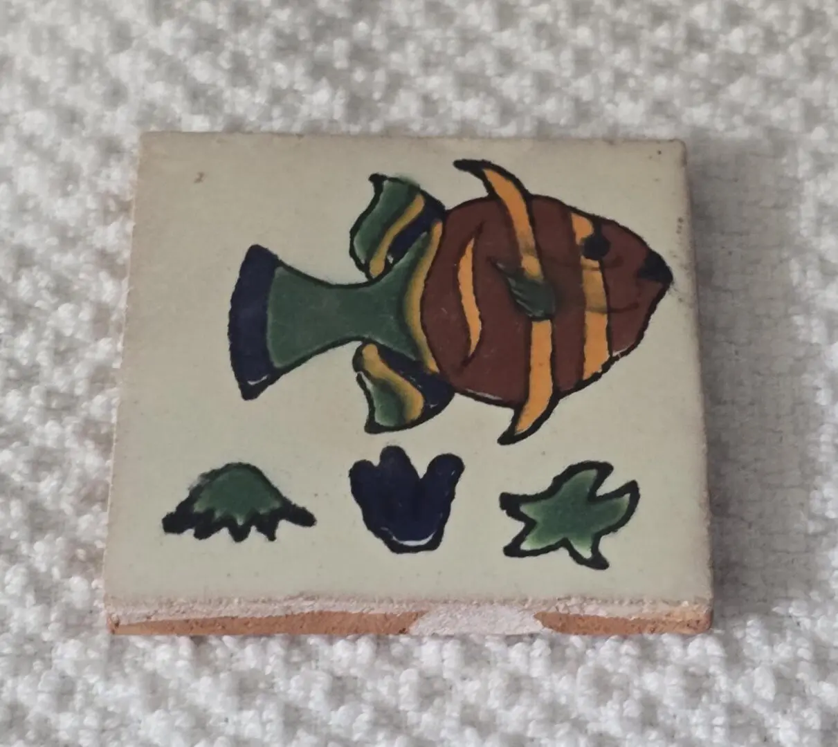Decorative tile with colorful fish design.