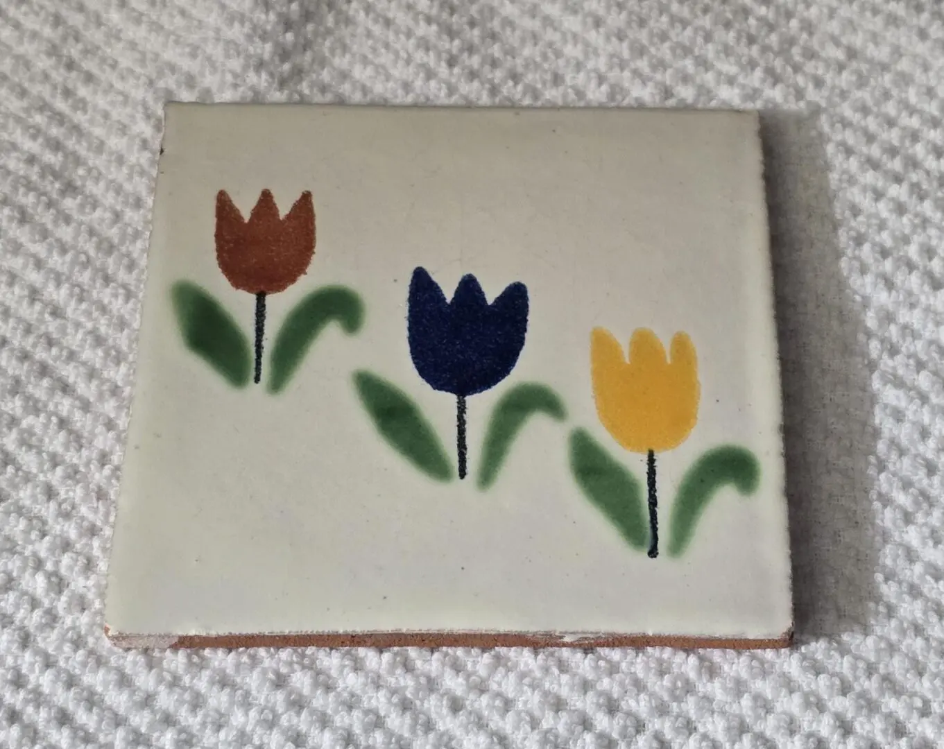 Tile with three colorful tulip designs.