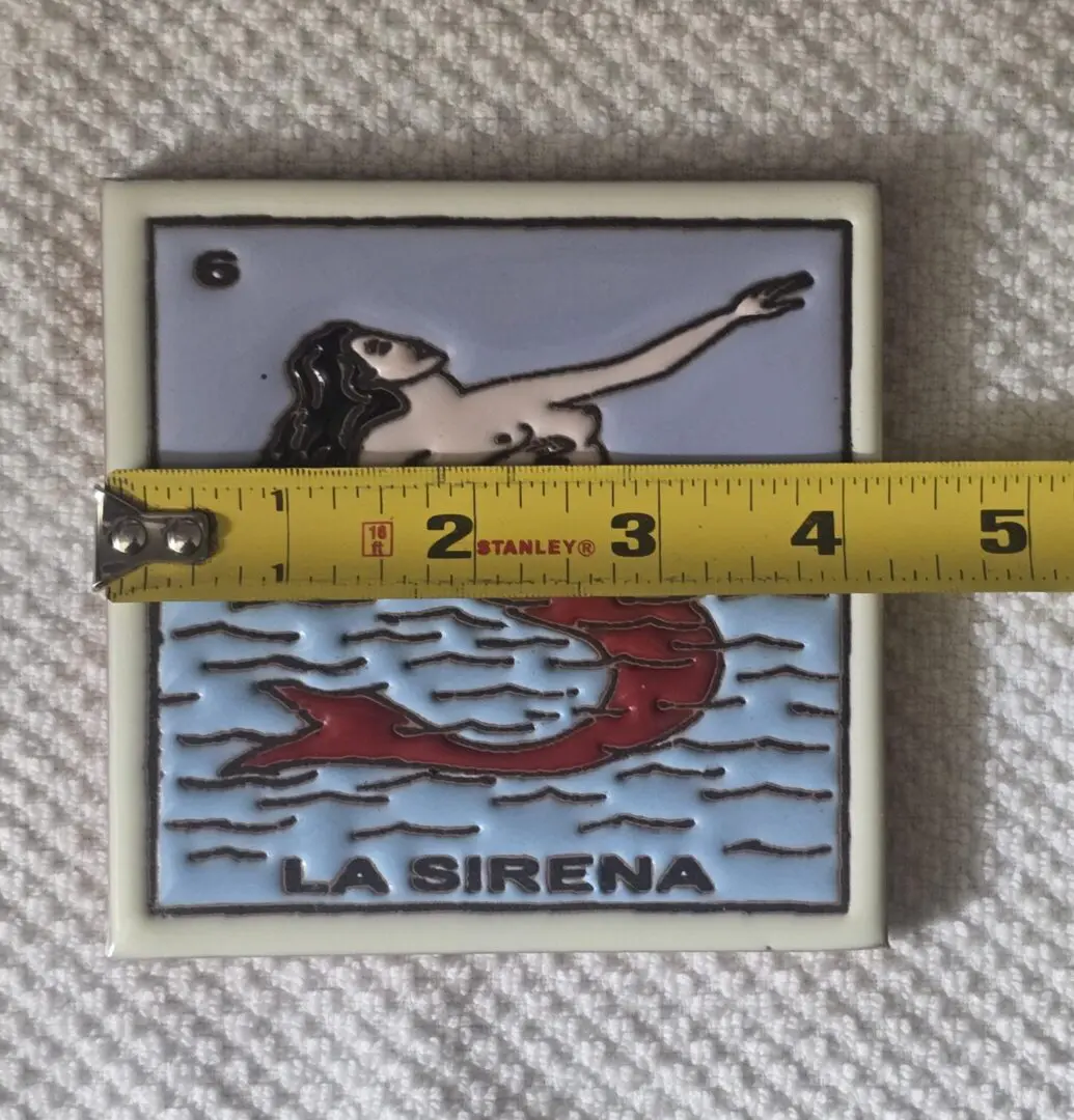 Mermaid tile with measuring tape across.