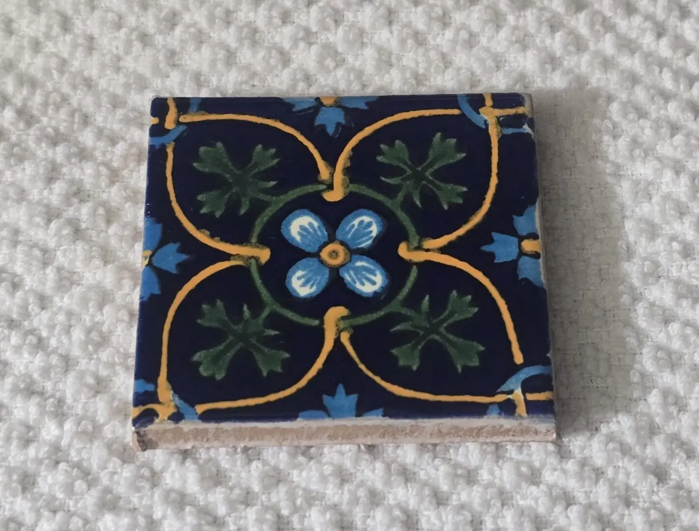Ornate navy ceramic tile with floral design