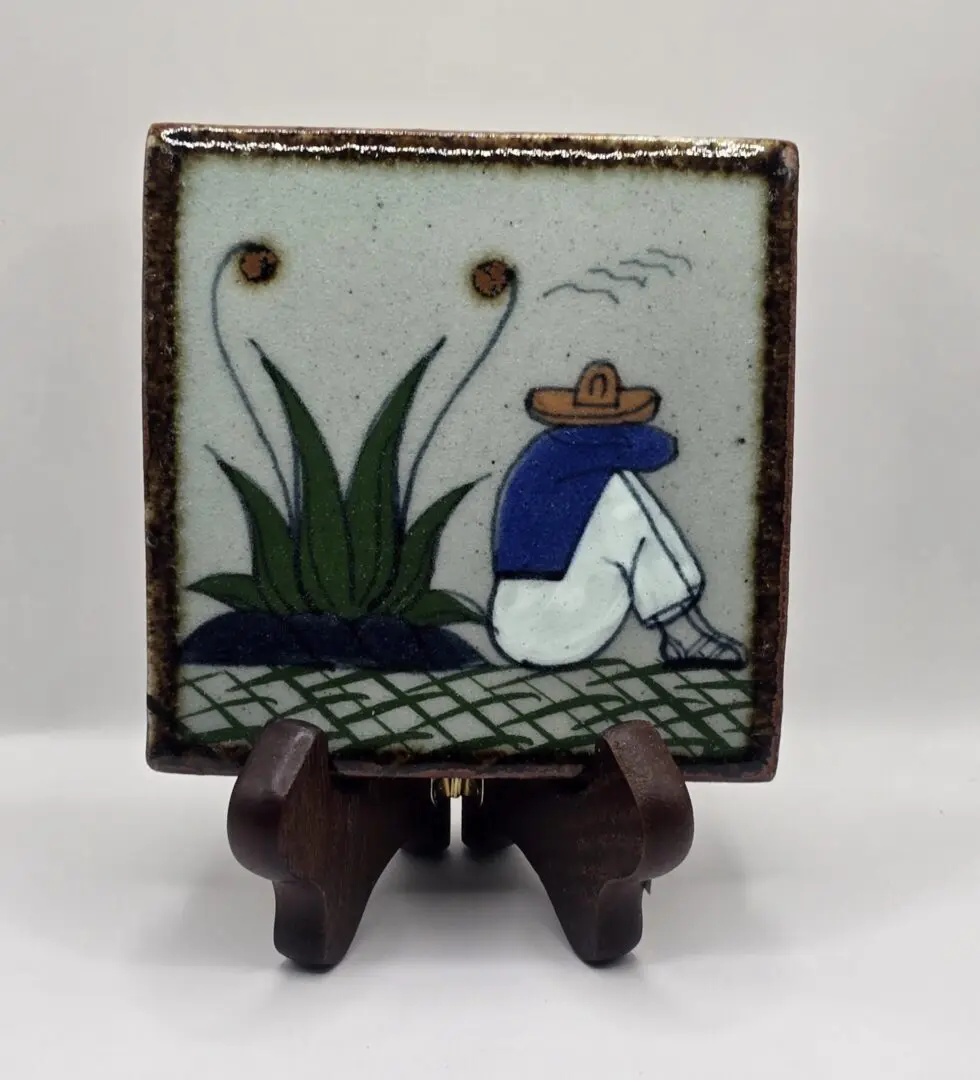 Ceramic tile with person and plants design.
