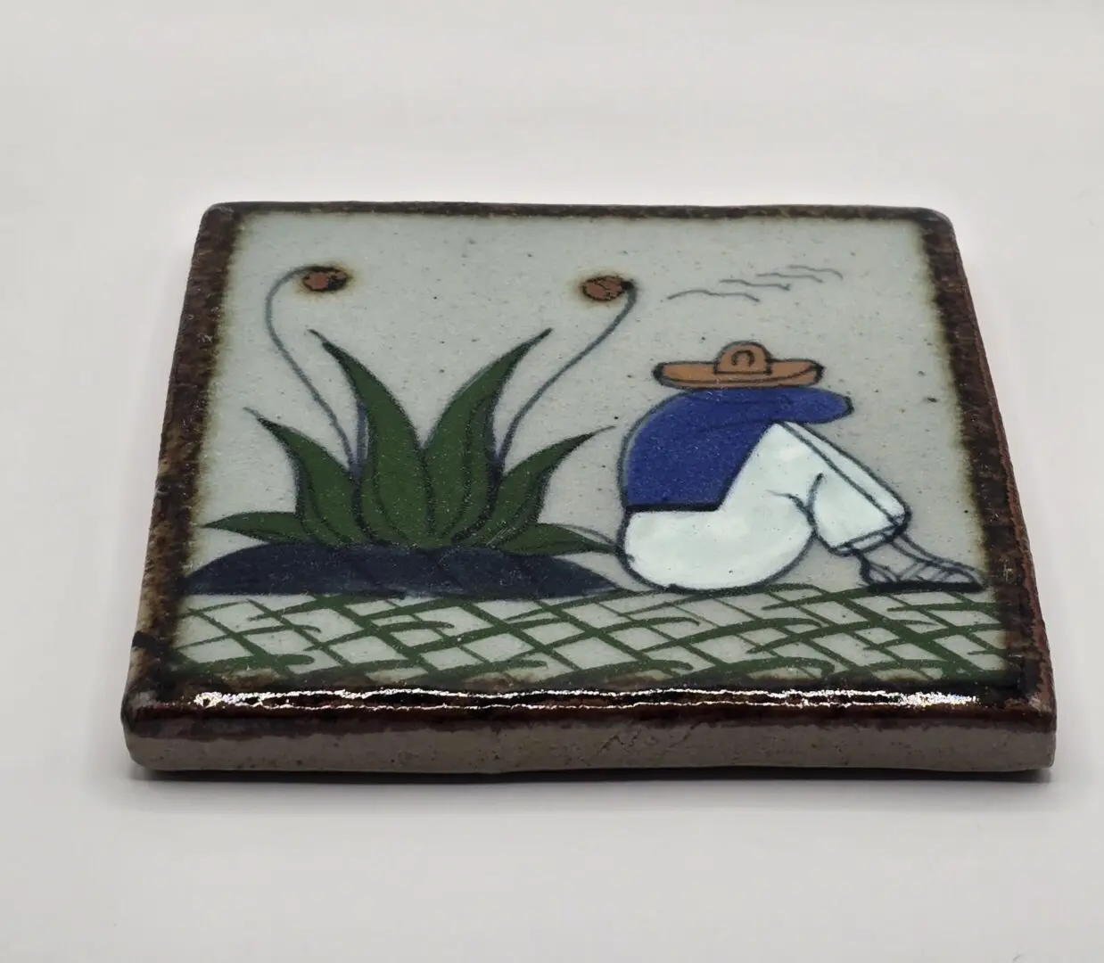 Tile with person and plant design.