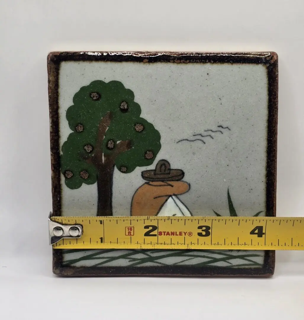 Ceramic tile with tree and tape measure.