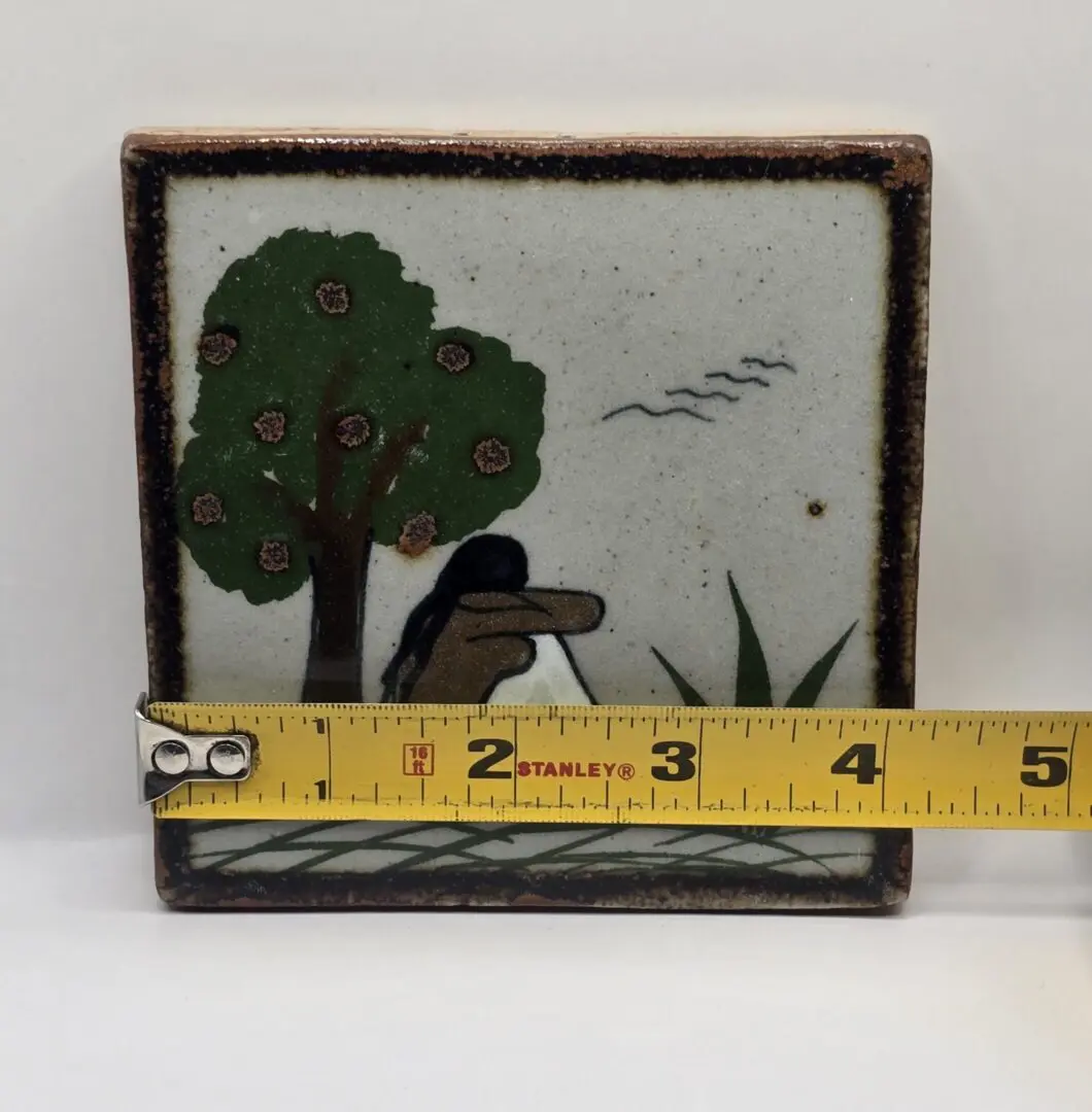 Decorative tile with measuring tape in foreground.