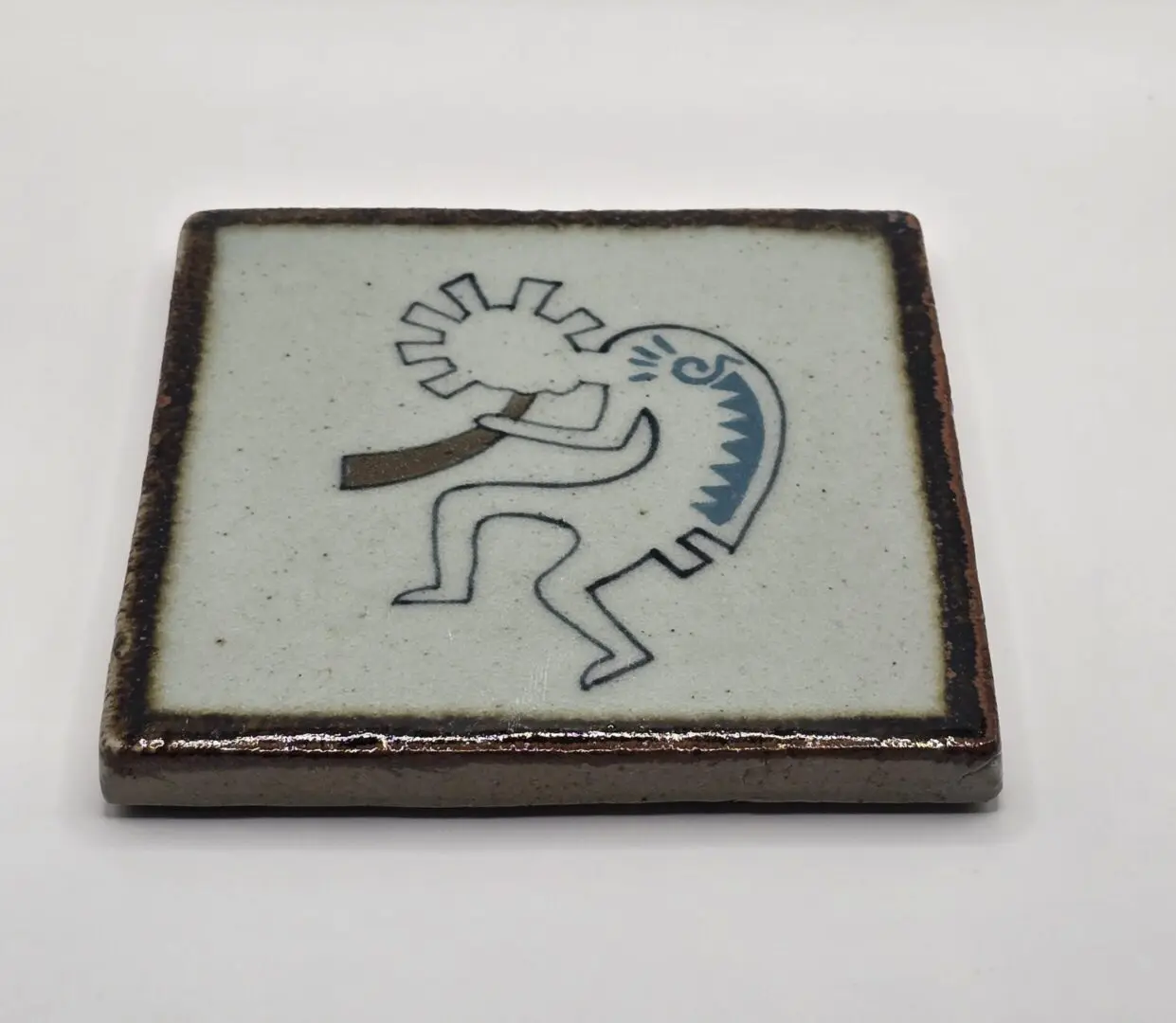 Tile with abstract figure and geometric design.