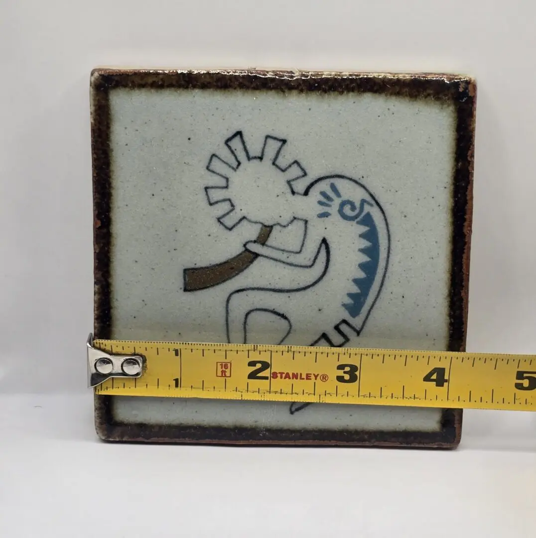 Ceramic tile with abstract figure and ruler.