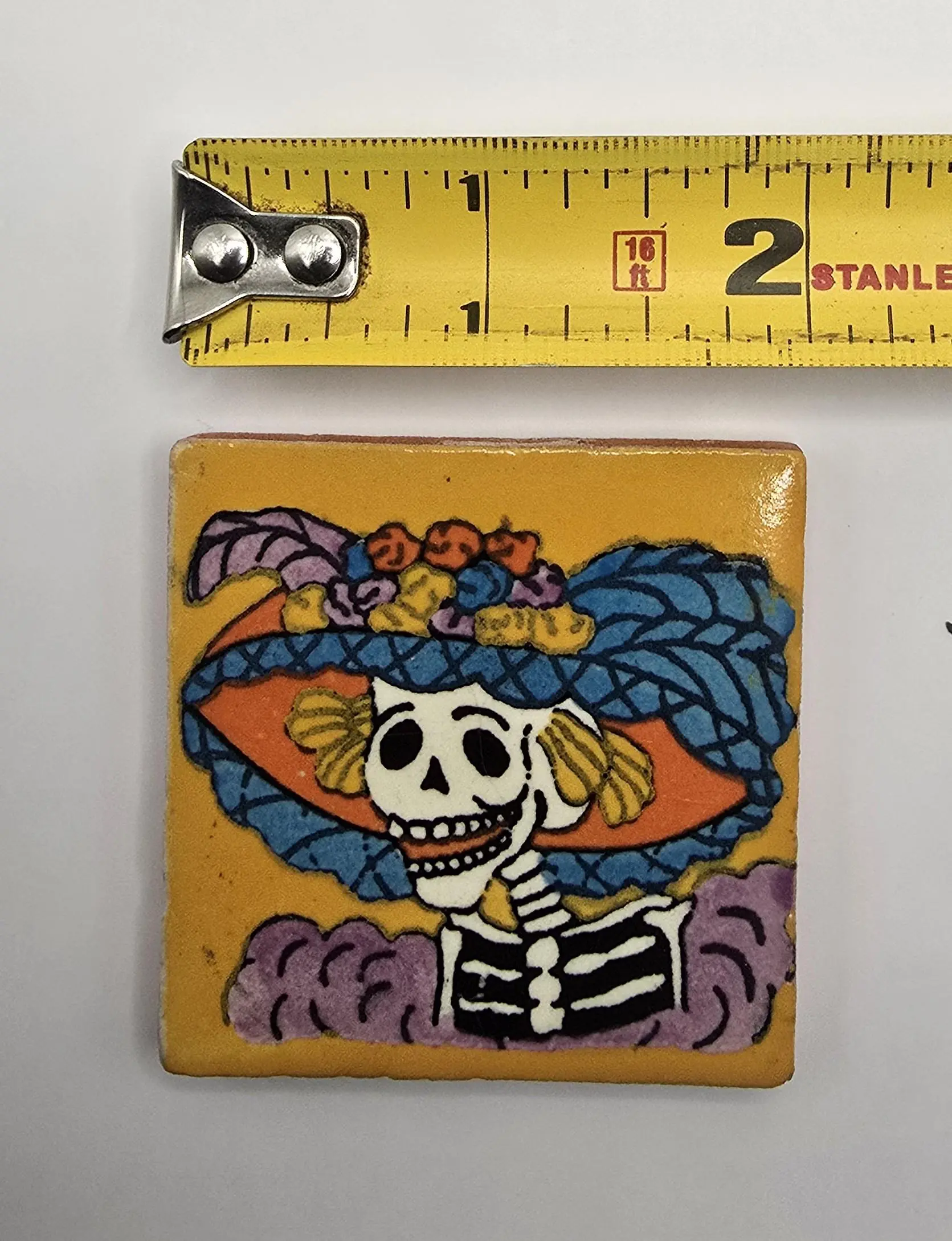 Tile with colorful skeleton artwork and ruler.