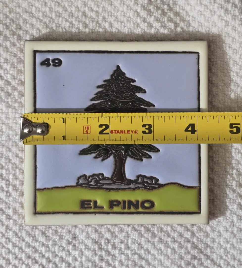 Tile with pine tree and measuring tape.