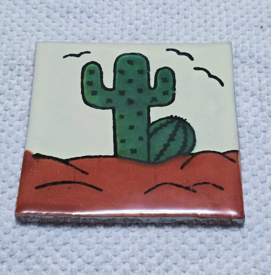 Tile with a cactus and desert scene.