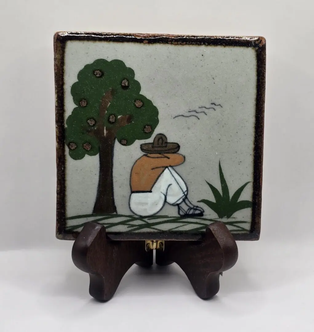 Man sitting under tree, ceramic tile art.