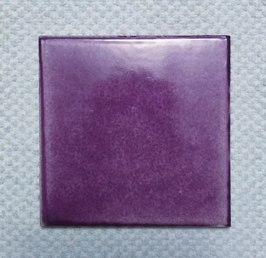 Square purple tile on textured background.