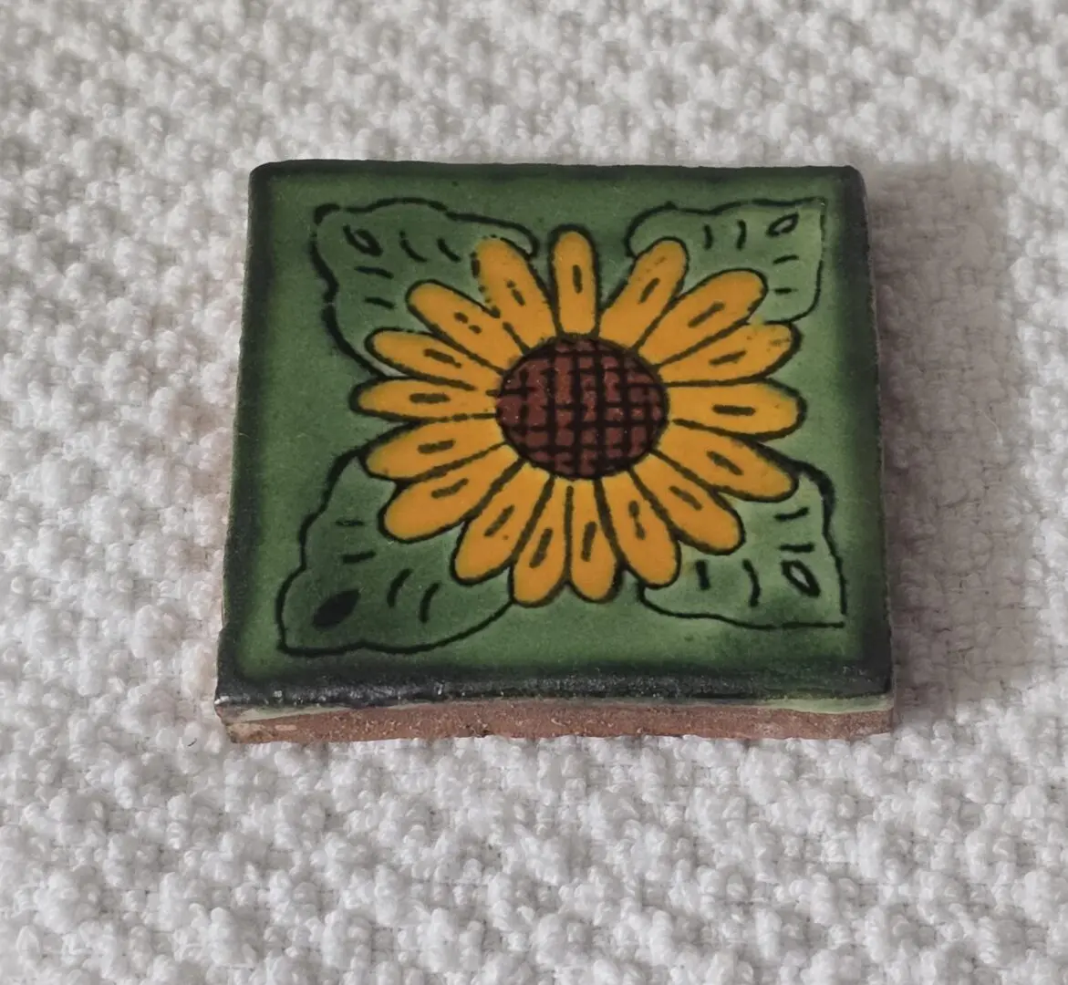 Colorful sunflower design on ceramic tile.