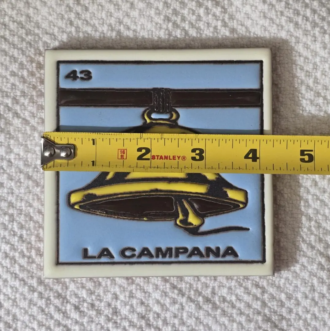 Tile with a bell design, measuring tape.