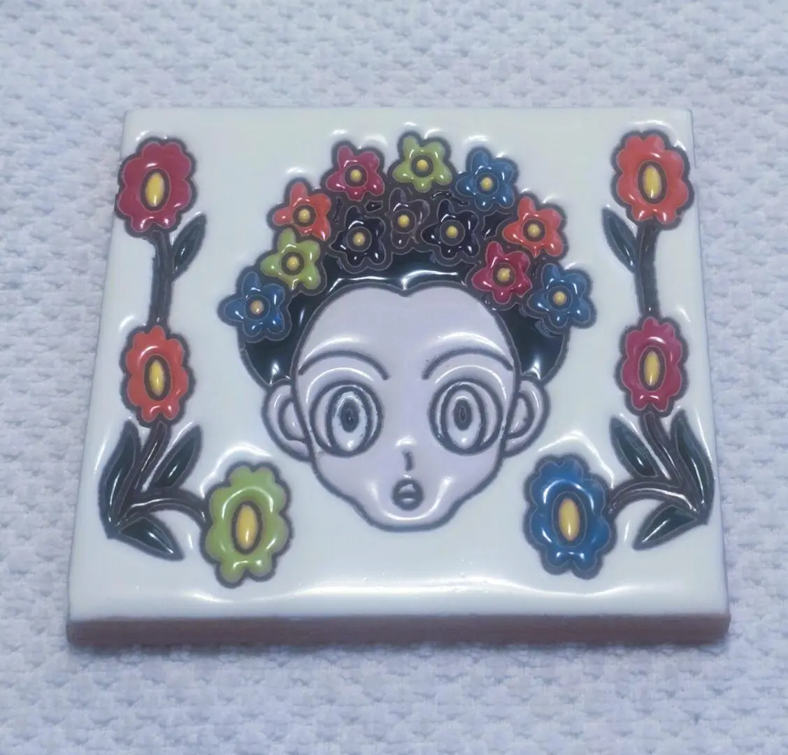 Cartoon face with colorful flowers on tile.
