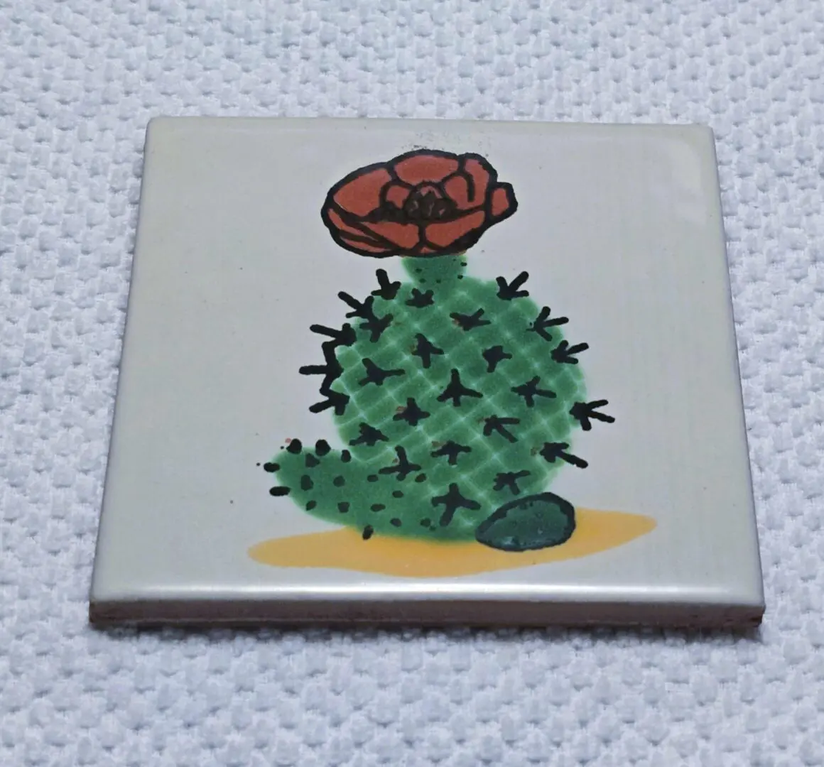 Tile with cactus and flower illustration.