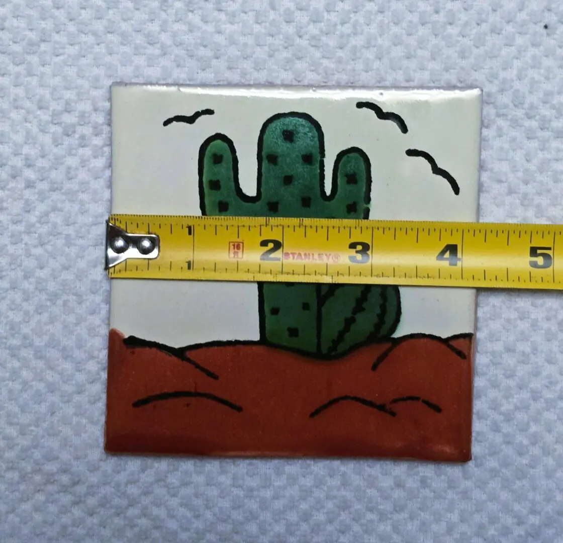 Tile with cactus design and measuring tape.
