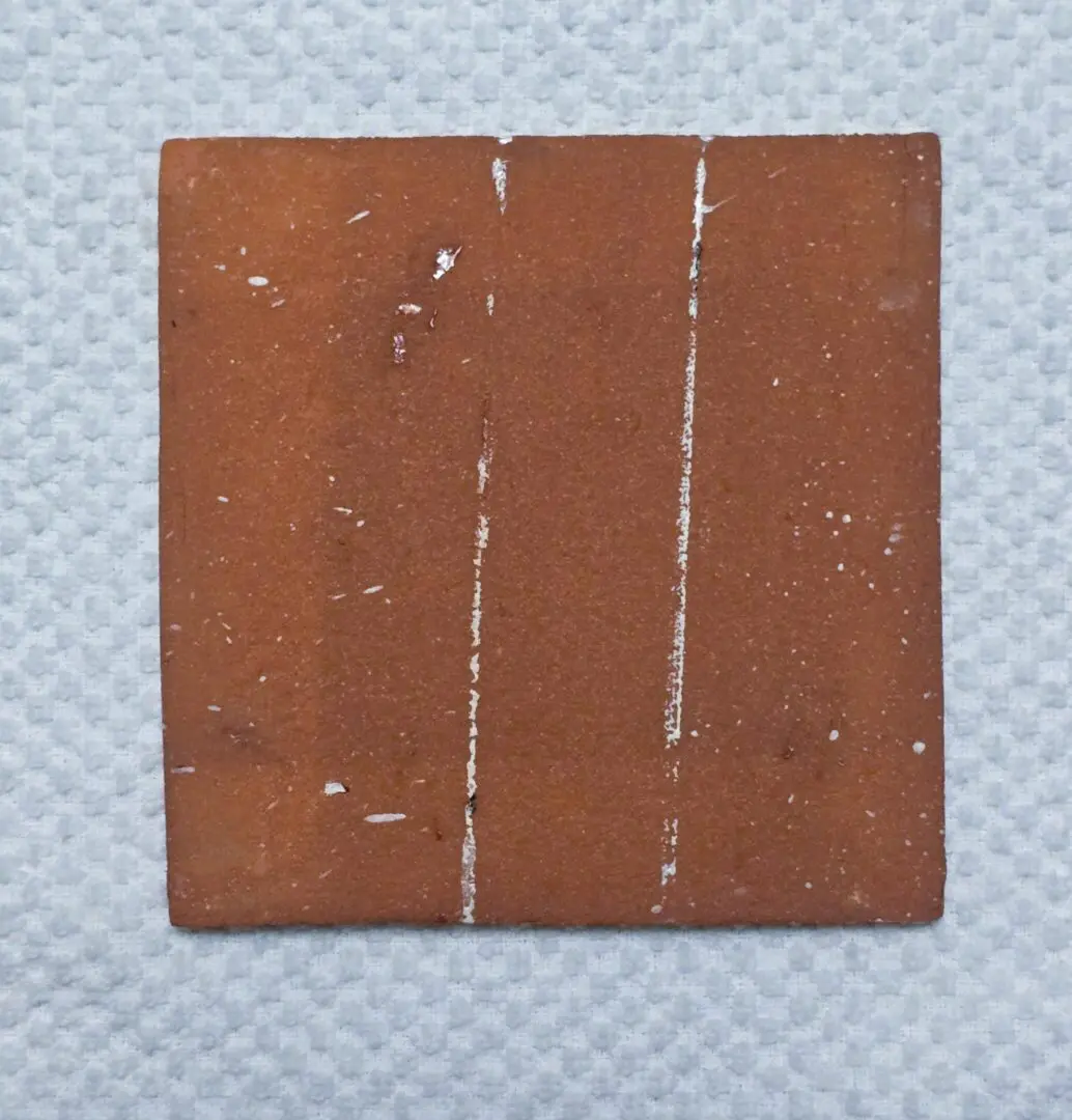 Brown square tile with vertical white lines.