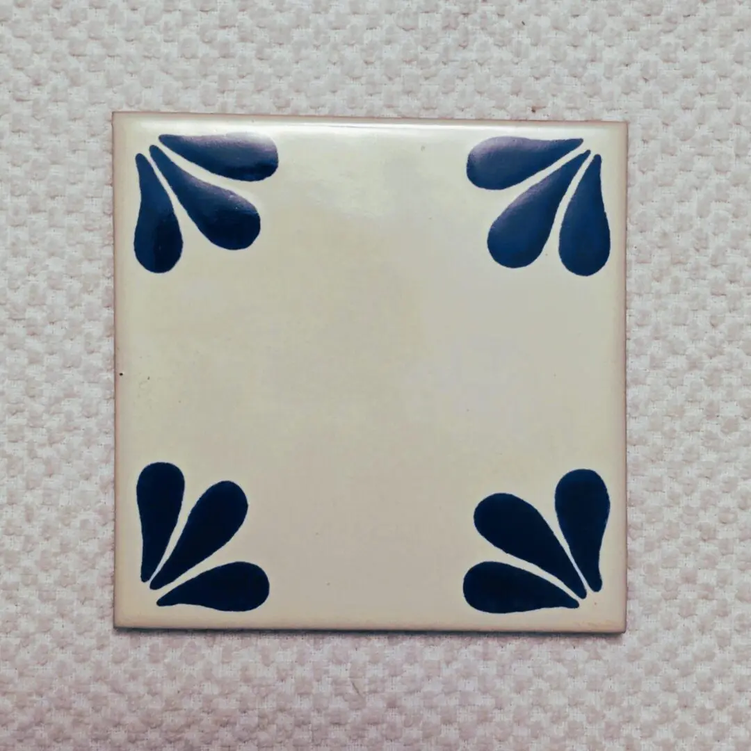 Ceramic tile with blue corner patterns.