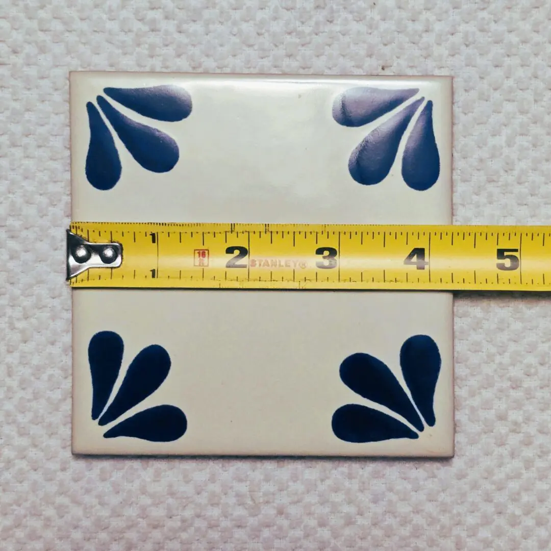 Tile with blue patterns and measuring tape.