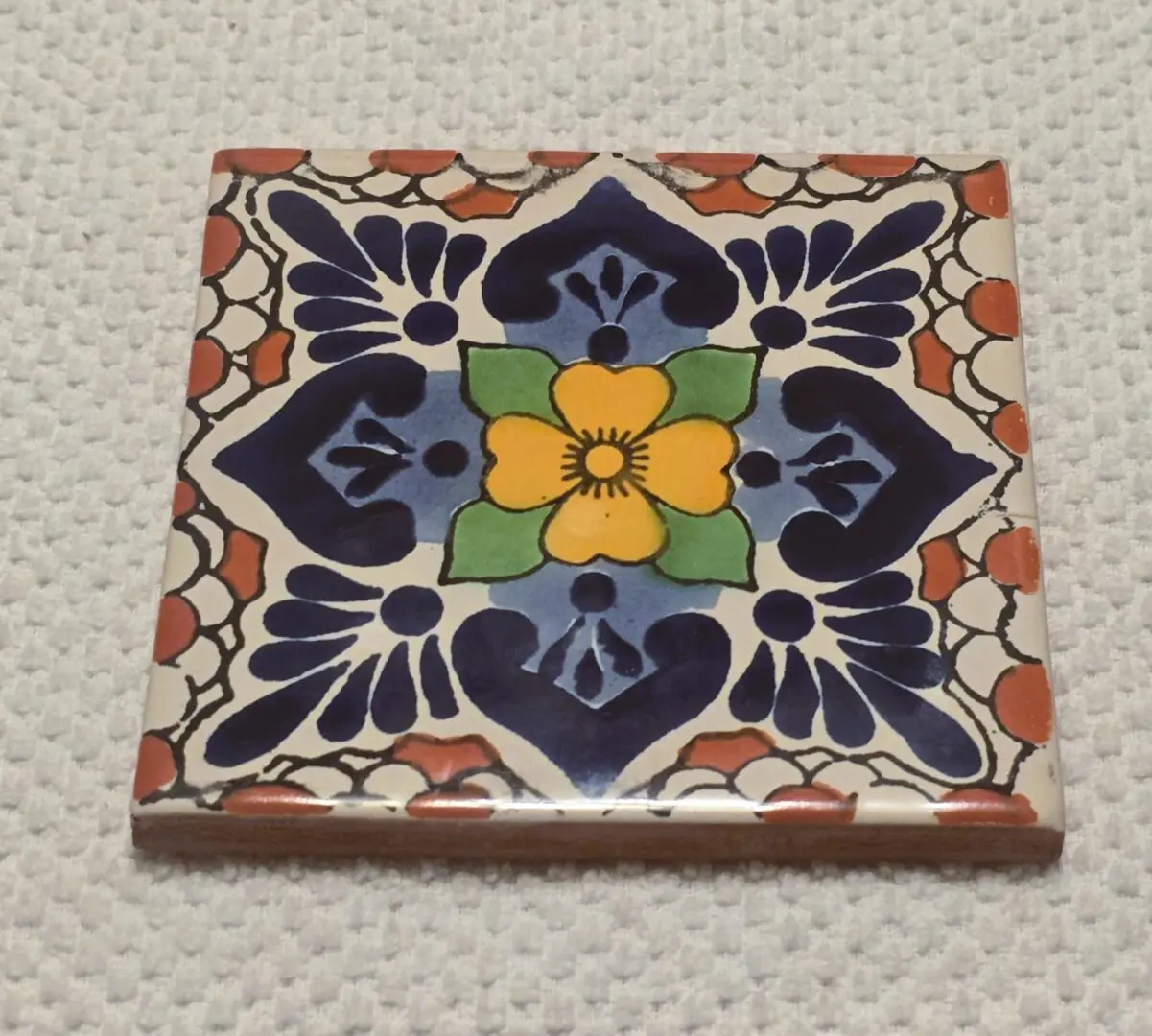 Hand-painted decorative ceramic tile with yellow flower