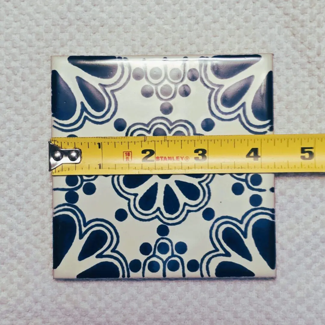 Decorative tile with measuring tape on top.