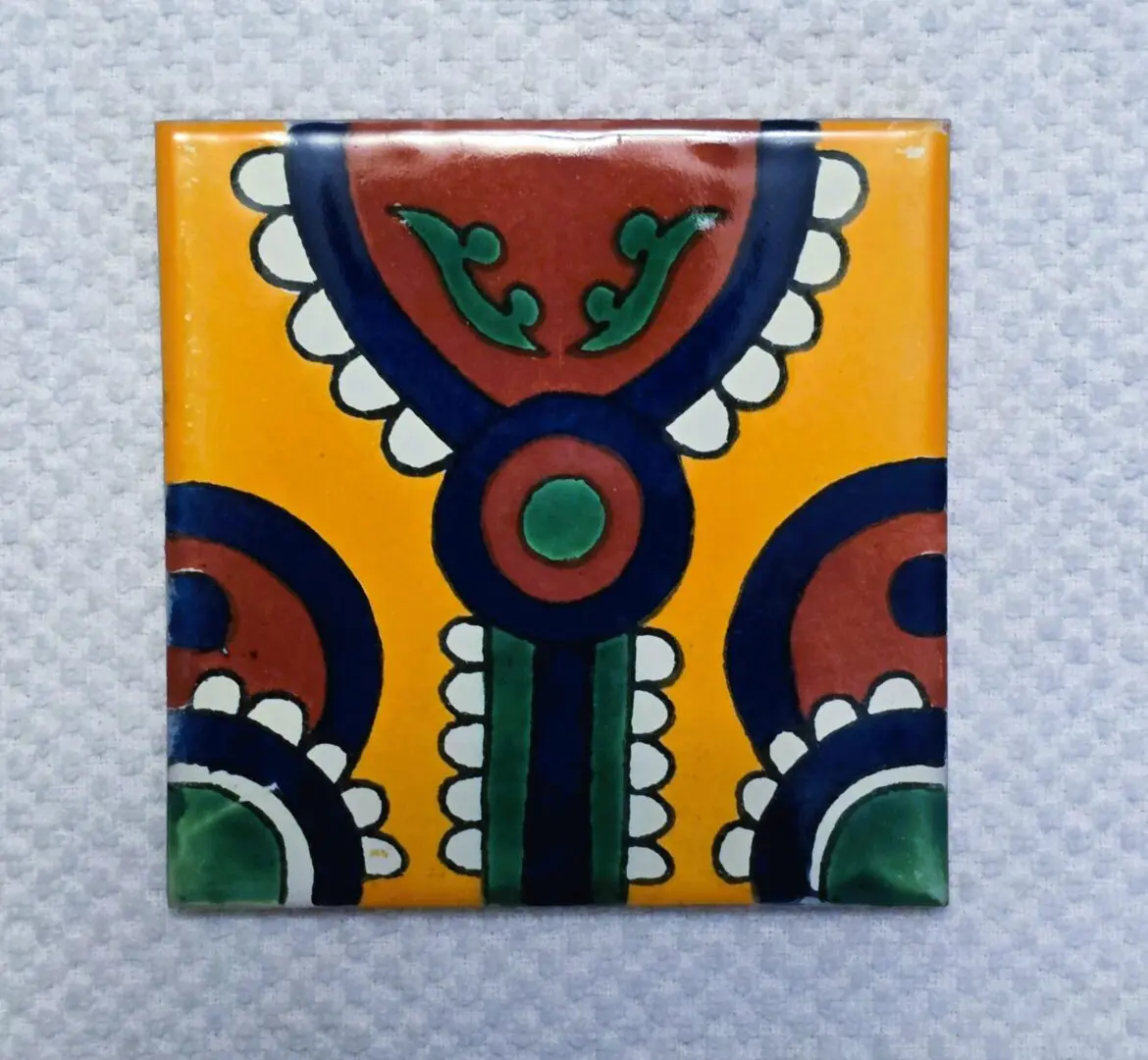 Hand painted yellow ceramic tile with stylized flowers