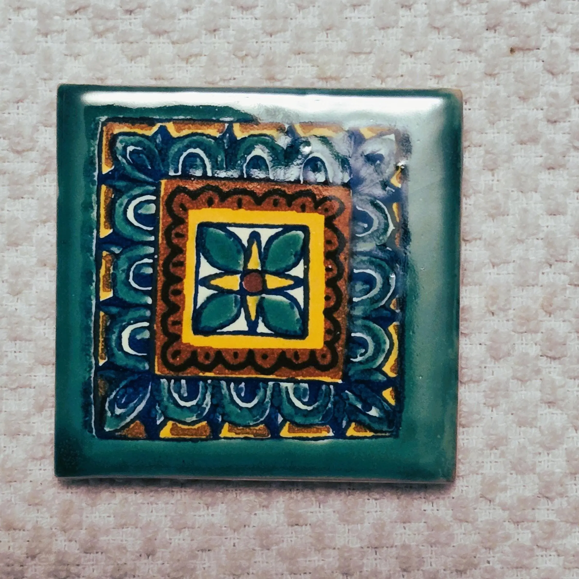 Colorful ceramic tile with intricate geometric design.