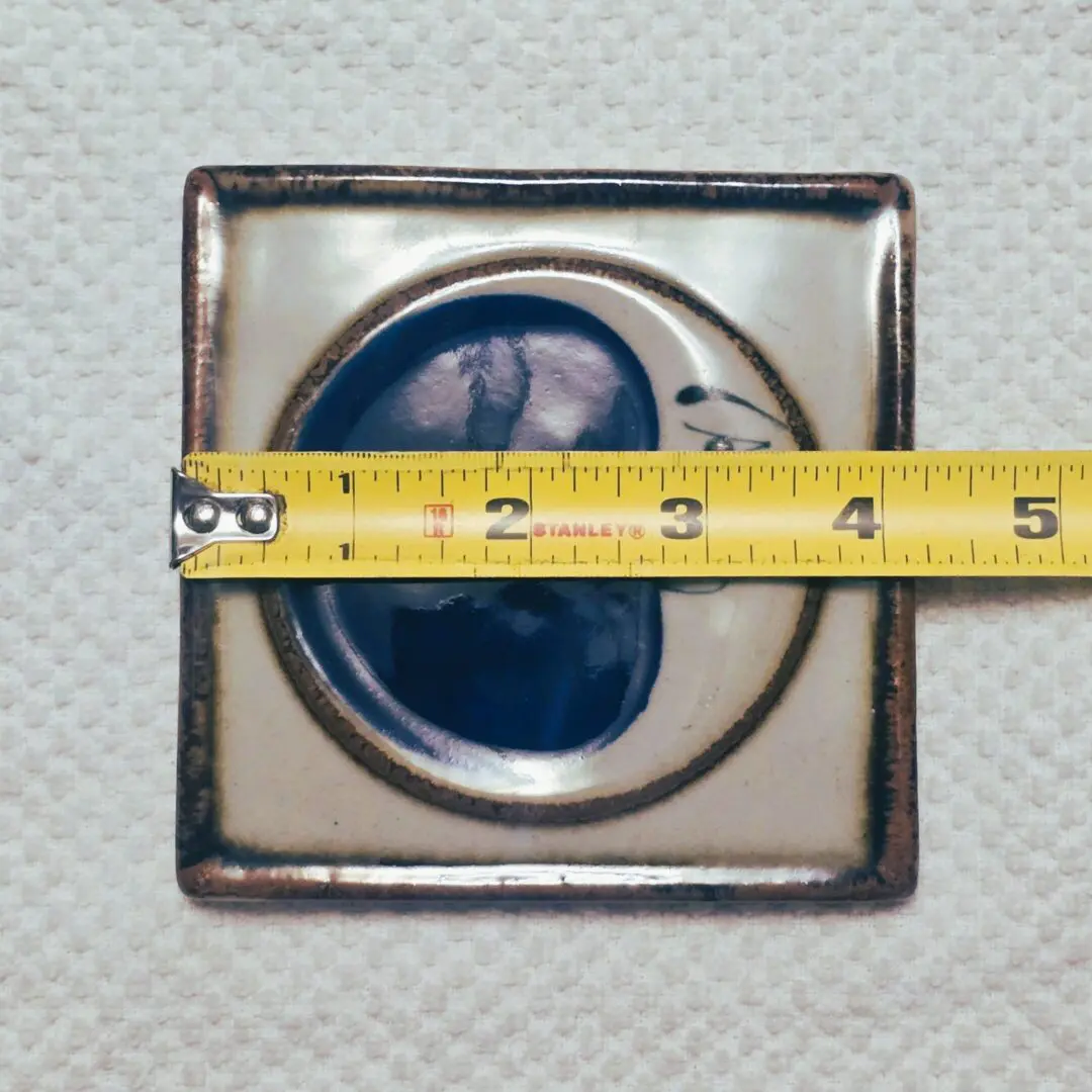 Measuring tape on ceramic tile with design.