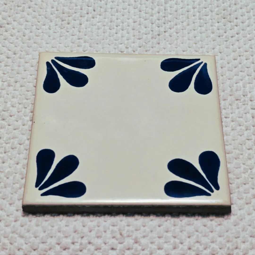 White tile with blue corner designs.