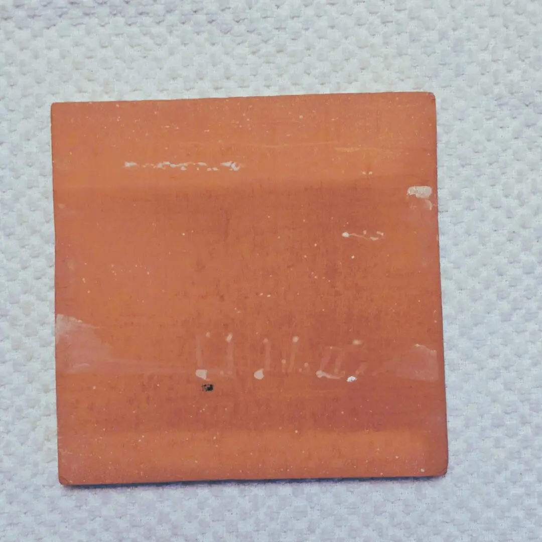 Worn square terracotta tile on paper towel
