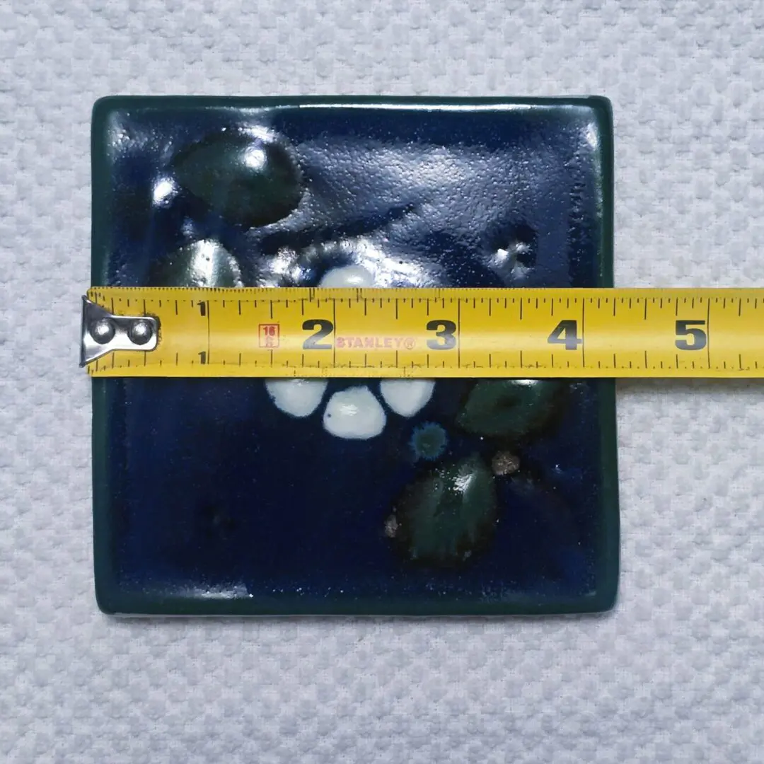 Square blue ceramic tile with tape measure