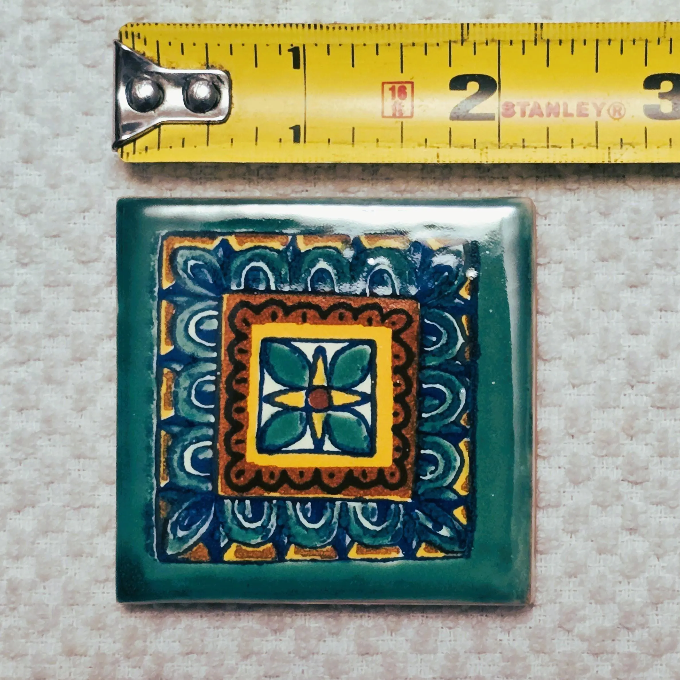 Colorful ceramic tile with floral motif and ruler
