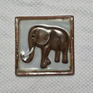 A ceramic tile with a raised elephant design.