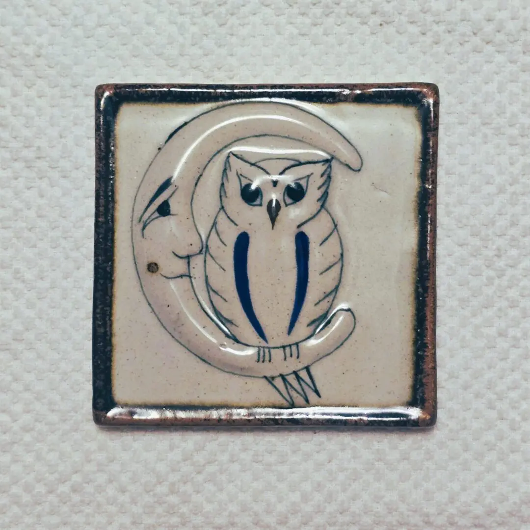 Ceramic tile with owl and crescent moon.