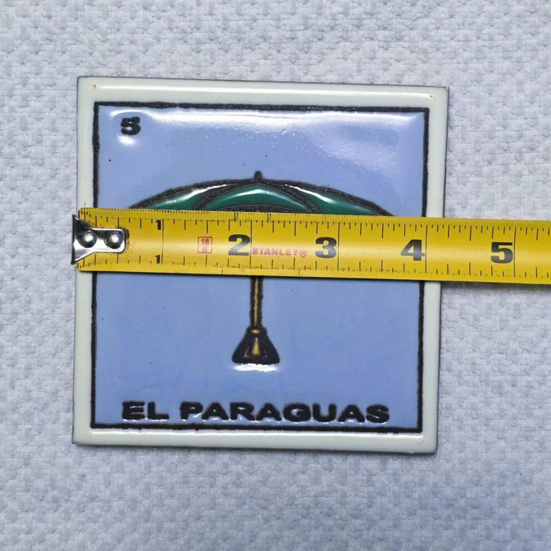 Tile with umbrella design and measuring tape.