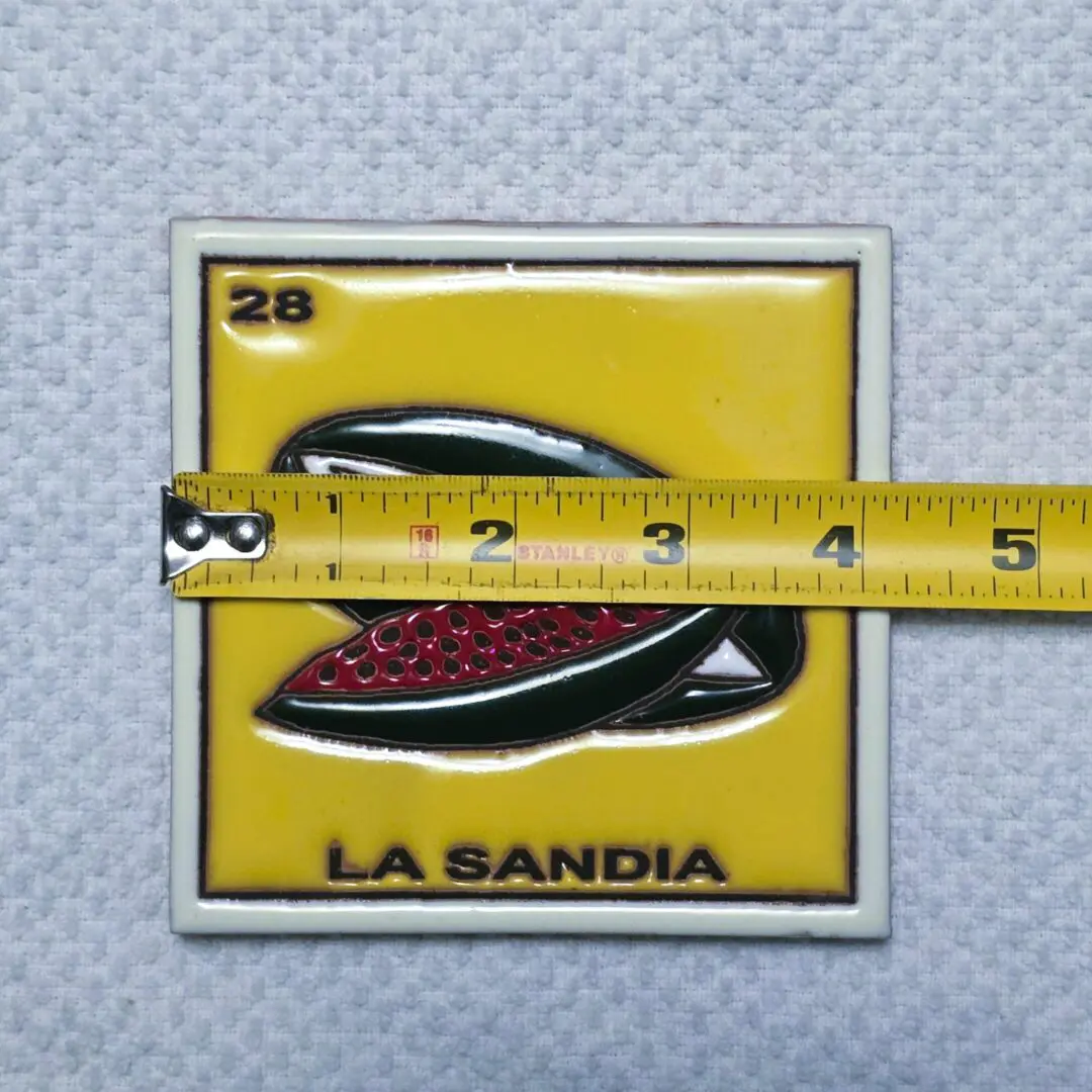 Yellow tile with watermelon and measuring tape.