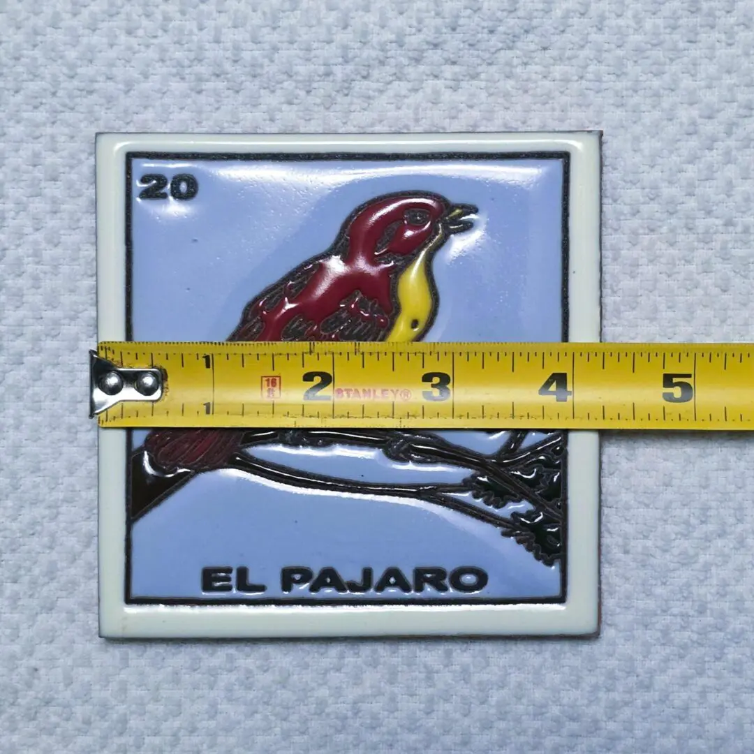 Tile with bird and measuring tape.