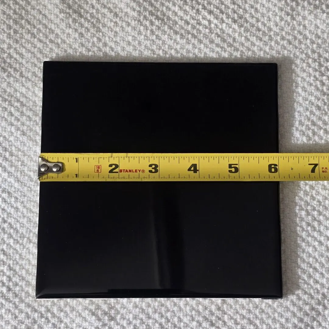 Black tile with yellow measuring tape.