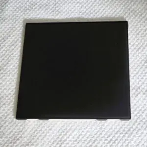 Black square object on textured surface.