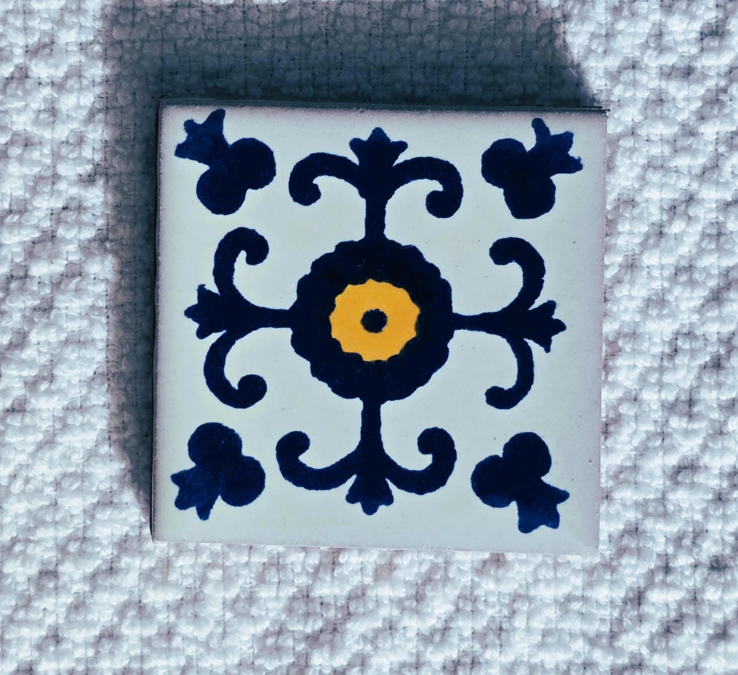 Decorative blue floral ceramic tile with yellow center