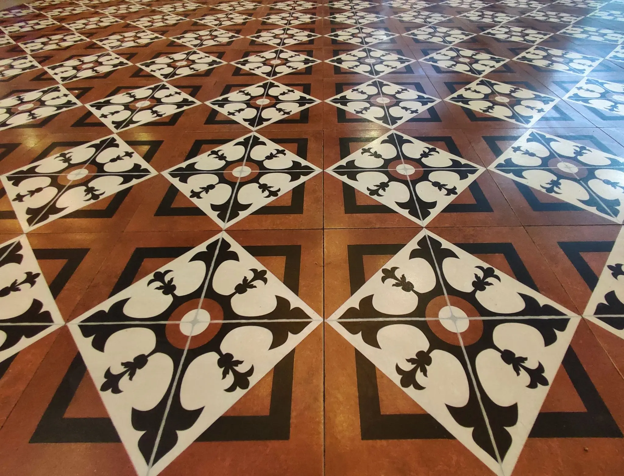 Intricate patterned floor tiles in warm tones of brown, black, and white.